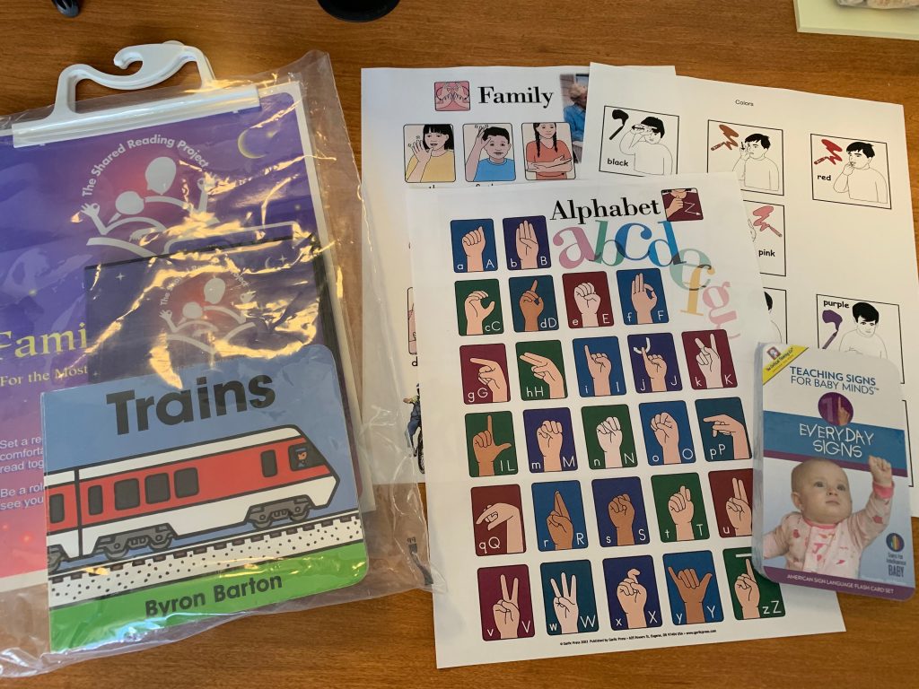 ABC in ASL sheet, Family ASL sheet, partial photo of book on trains, and text Resources.