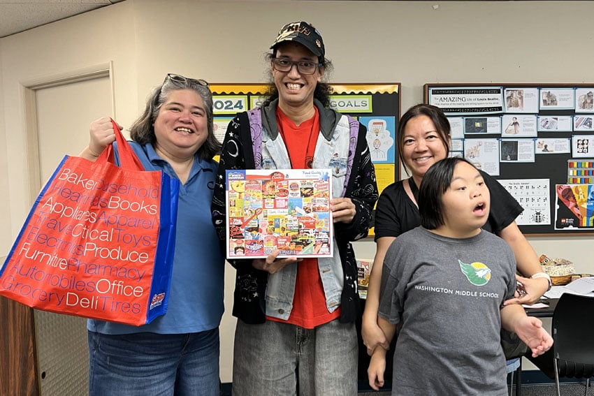 Photo: Group photo of Roz, Abraham, Chie, and Reina, with Abraham holding a new puzzle