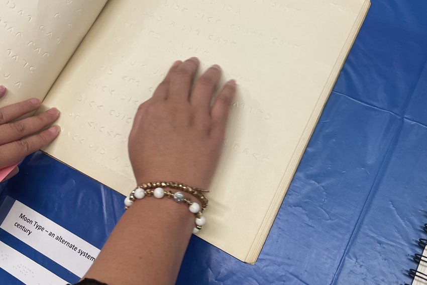 Photo: Woman reading braille
