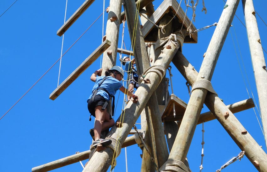Photo: Camp Manoa participant on a  climbing tower