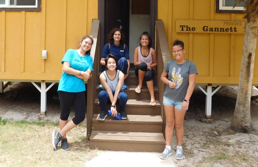 Photo: Camp Participants sitting outside a bungalow